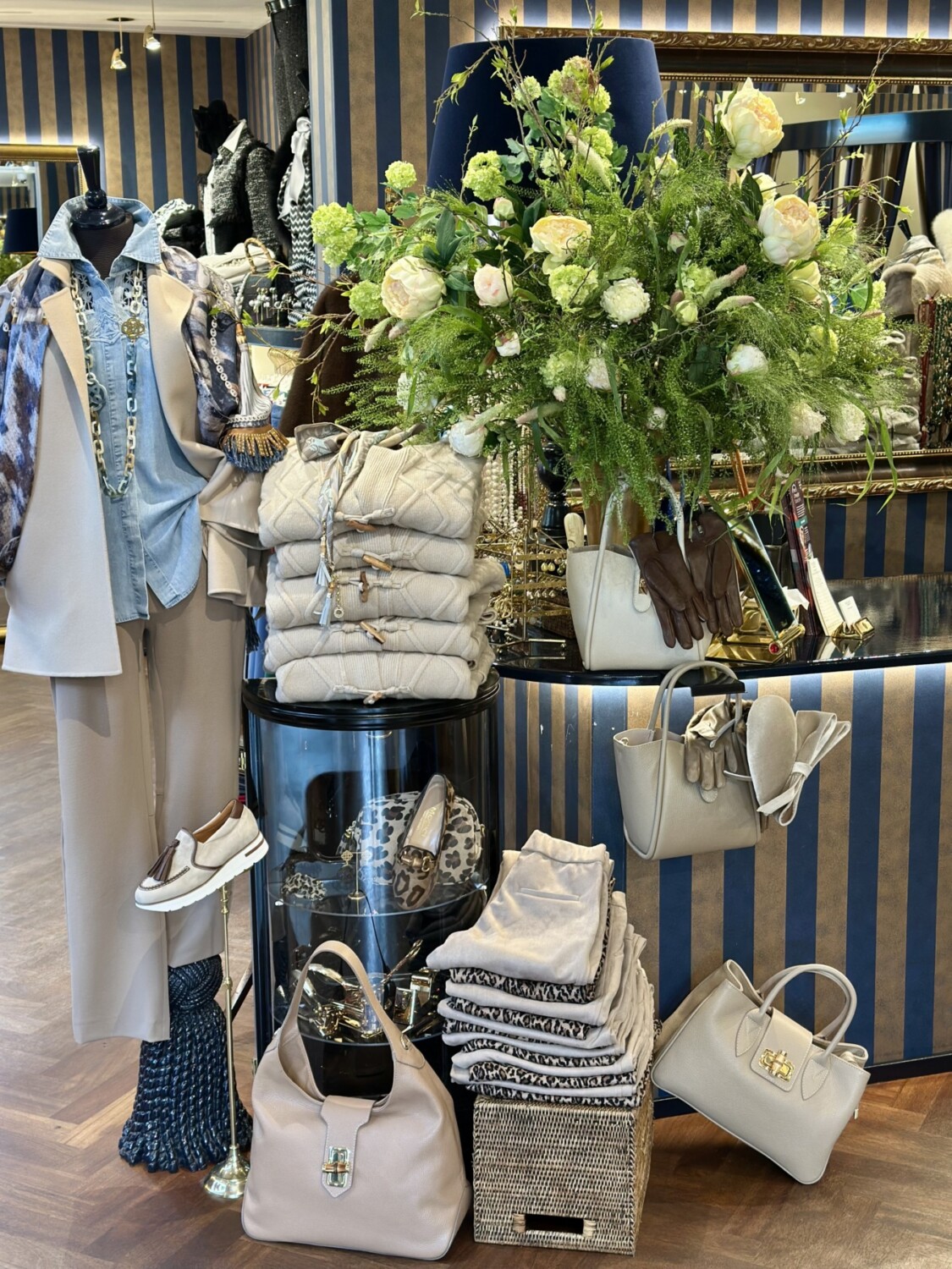 Luxueuze display met vrouwenmode, accessoires en bloemen bij Modici. Elegante kleding, tassen en schoenen voor stijlvolle outfits.