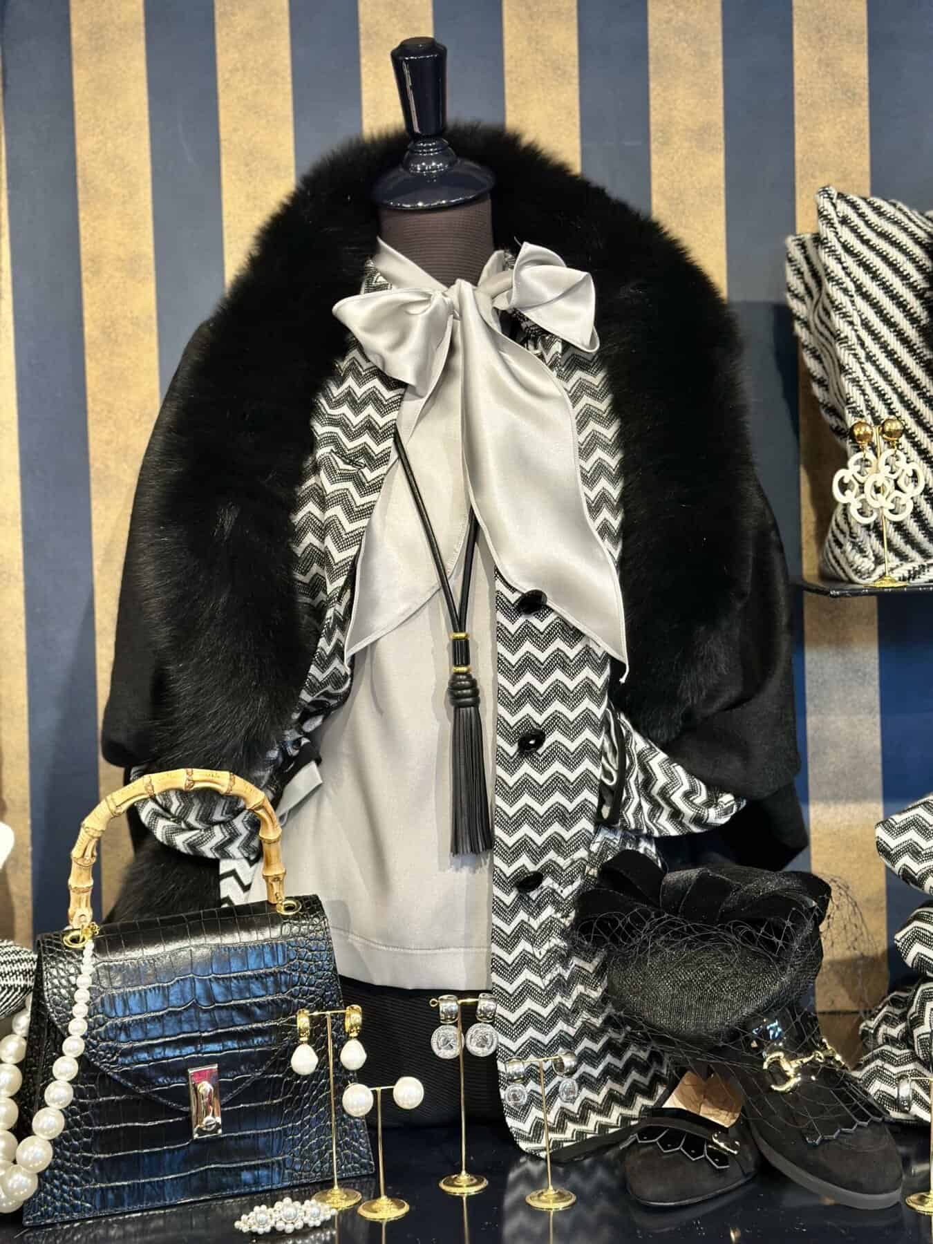 foresti vest in zwart wit en bont cape Elegant damesoutfit met zwart-witte print, zijden strik en accessoires, perfect voor modieuze gelegenheden.foresti vest zwart wit Missoni motief